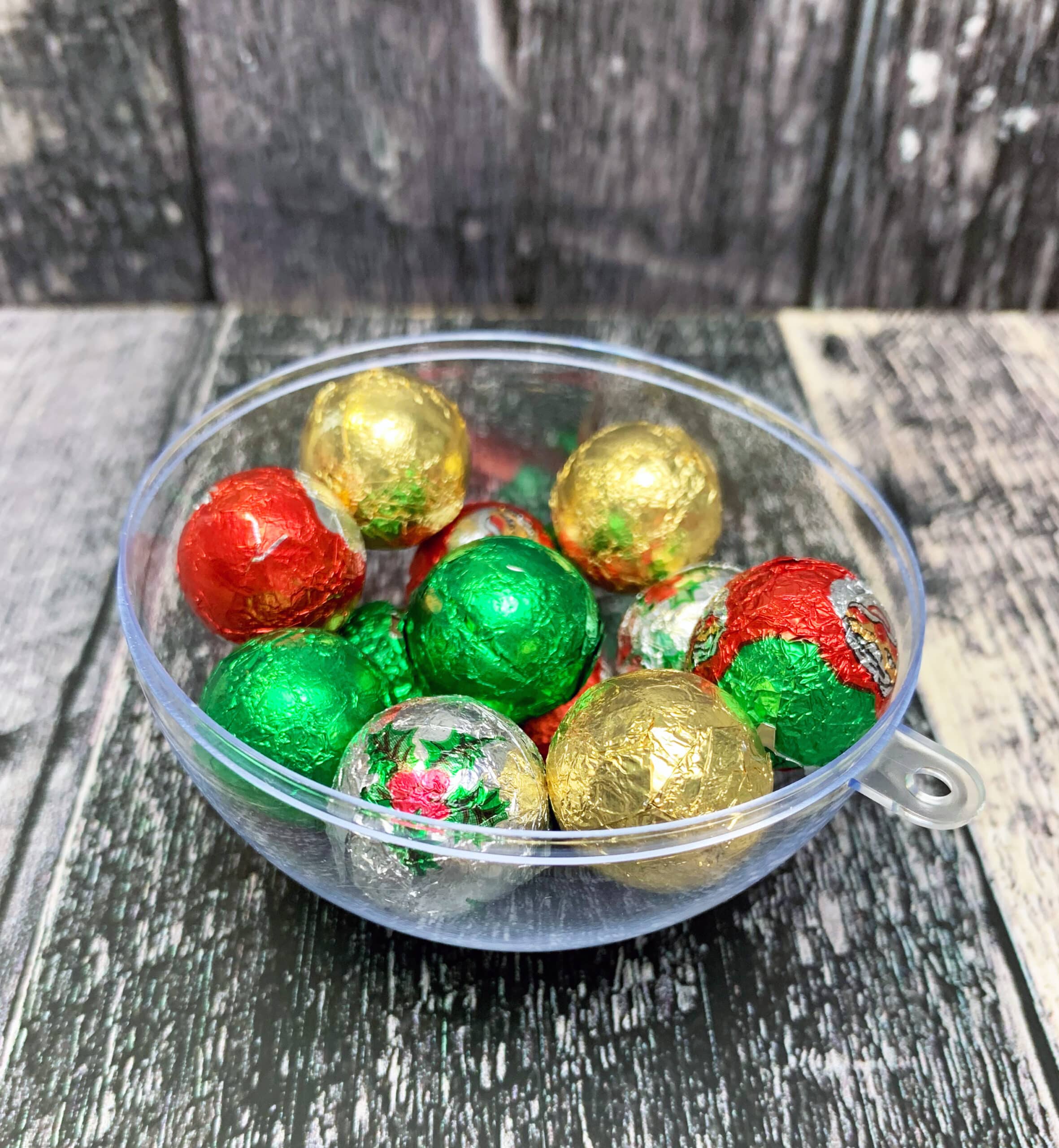 Bonbons dans la boule de Noël en plastique transparente